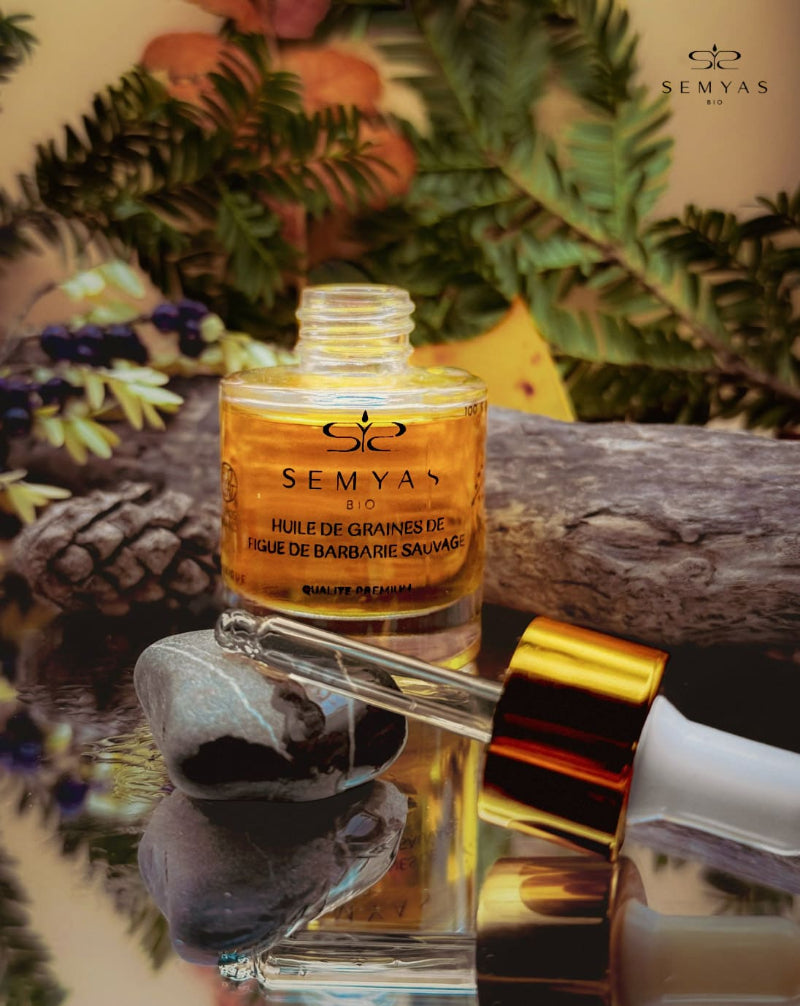 Flacon d’huile de graines de figue de barbarie sauvage bio SEMYAS posé sur un fond naturel, avec une pipette dorée et des éléments végétaux — huile précieuse 100 % pure et pressée à froid, reconnue pour ses bienfaits hydratants, réparateurs et anti-âge pour la peau et les cheveux.