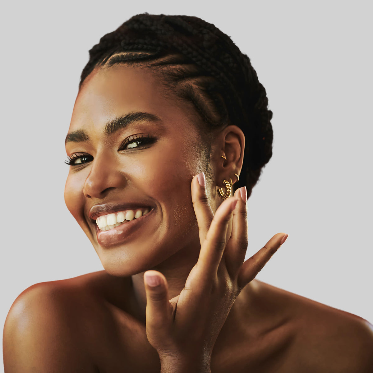 Femme souriante appliquant de l’huile de figue de barbarie sauvage bio sur sa peau, symbole de beauté naturelle, d’hydratation profonde et d’éclat du teint.